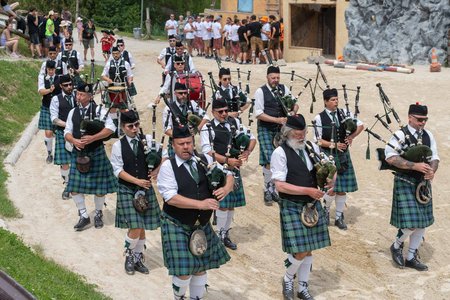 Marschkapelle mit Männern in Schottenröcken spielt auf Dudelsäcken und Trommeln