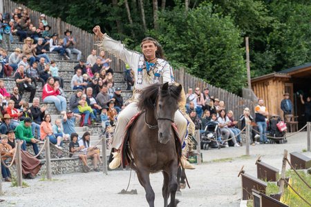 Mann in Indianerkleidung reitet auf Pferd
