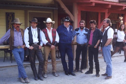 Sieben Männer in Westernkleidung