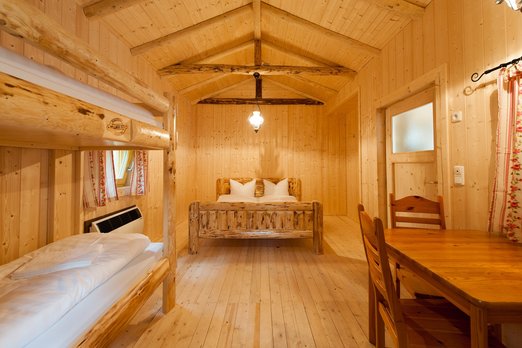 Hotelzimmer in einer Blockhütte mit Doppelbett und einem Stockbett