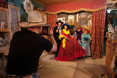 Mann fotografiert Familie in authentischer Kleidung