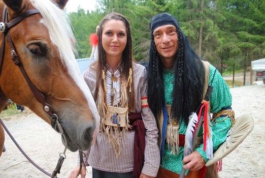 Zwei Personen in Indianerkostüm mit einem Pferd